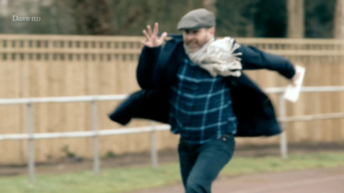 [ID: Five Screencaps Of Dave Gorman On Taskmaster, Traversing An Outdoor Athletics Track With Comically