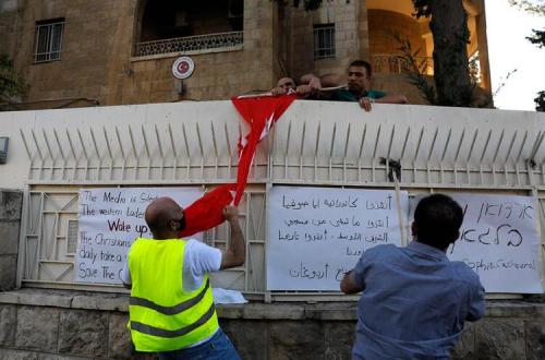 Palestinian Christians pull down a Turkish flag as security guards try to prevent them, outside the 