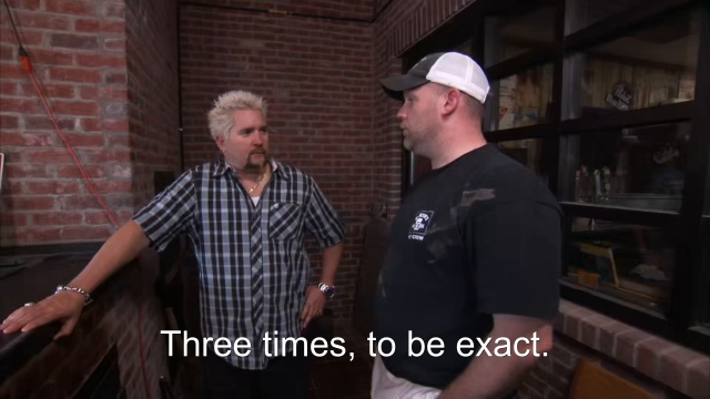 92% sure it's Guy Fieri standing next to a building. Caption: Three times, to be exact.