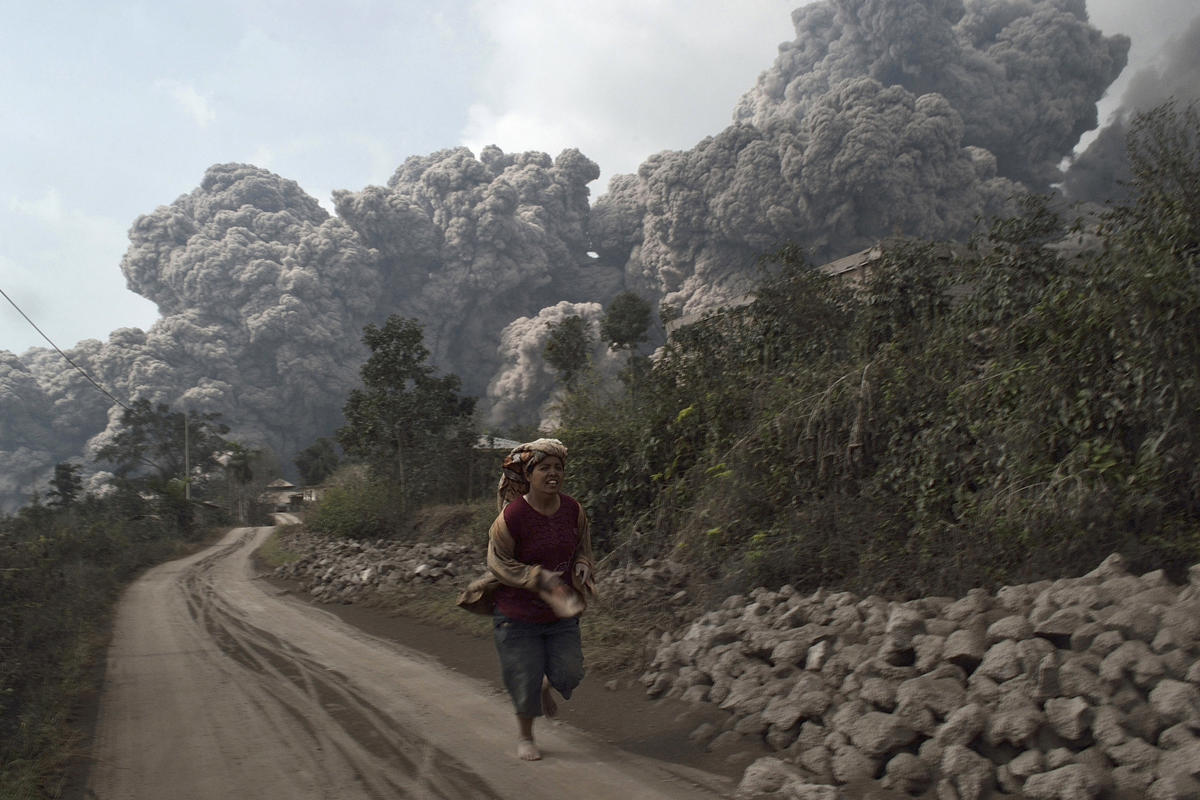 A villager runs as Mount Sinabung erupts in Indonesia’s North Sumatra province (Photo by S. Aditya/Reuters via Yahoo News)