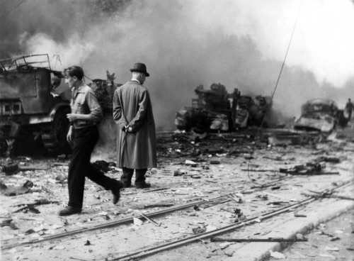 Serbian civilians inspect the flaming wreckage of German military vehicles on the Boulevard of the R