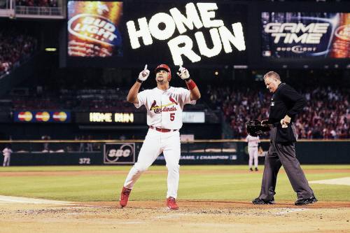 Albert Pujols points up to the sky as he crosses home plate after hitting a two-run home run during 