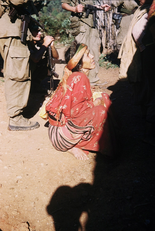 Algeria. A scared elderly woman being questioned by French soldiers about family members or neighbor