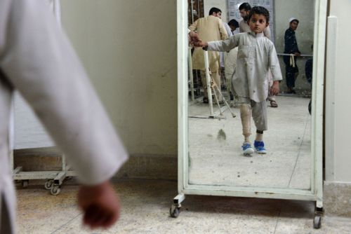 A child practices walking with his new prosthetic leg at a hospital for war victims and the disabled