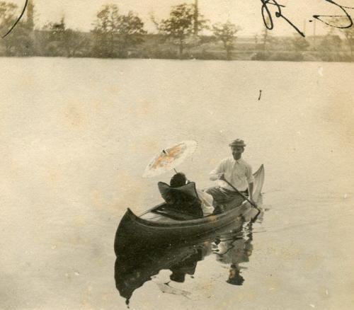 hauntedbystorytelling:Vintage photo of couple in a rowing canoe with parasol, Providence, RI, early 