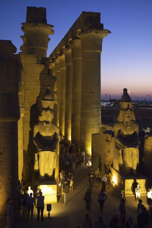 Luxor Temple at night with two colossal statues of Ramesses II illuminated