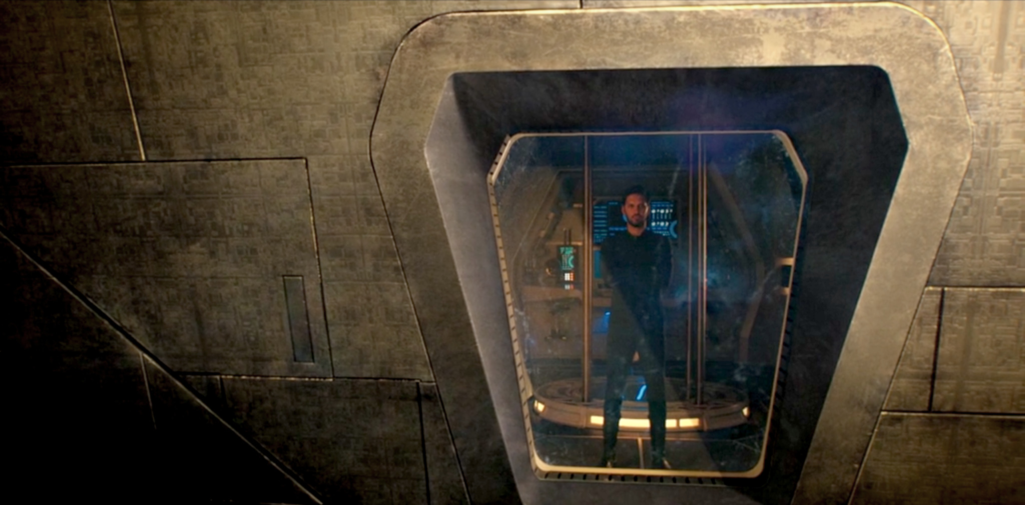 Image ID: a screenshot of Ash Tyler from star trek: discovery. He is standing in front of a full length window, looking out. End ID