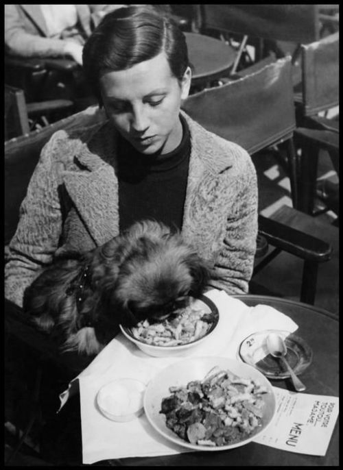 Robert Capa, Paris. Ca. 1936. Gerda TARO at a cafe with a little dog.