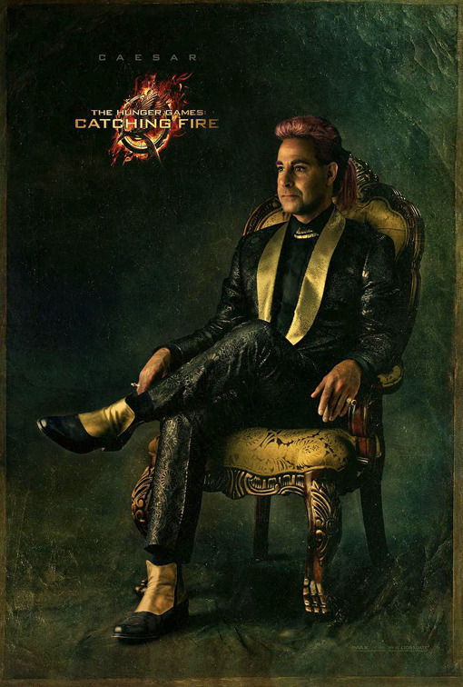 Hunger Games host Caesar Flickerman knows how to rock a pink pompadour and a patterned suit.