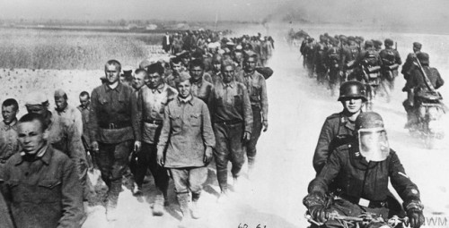 German motorcycle troops and infantry pass a long column of Russianprisoners during the advance into