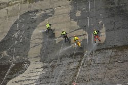 itscolossal:  Giant ‘reverse graffiti’ mural spray-washed onto the side of a Polish dam
