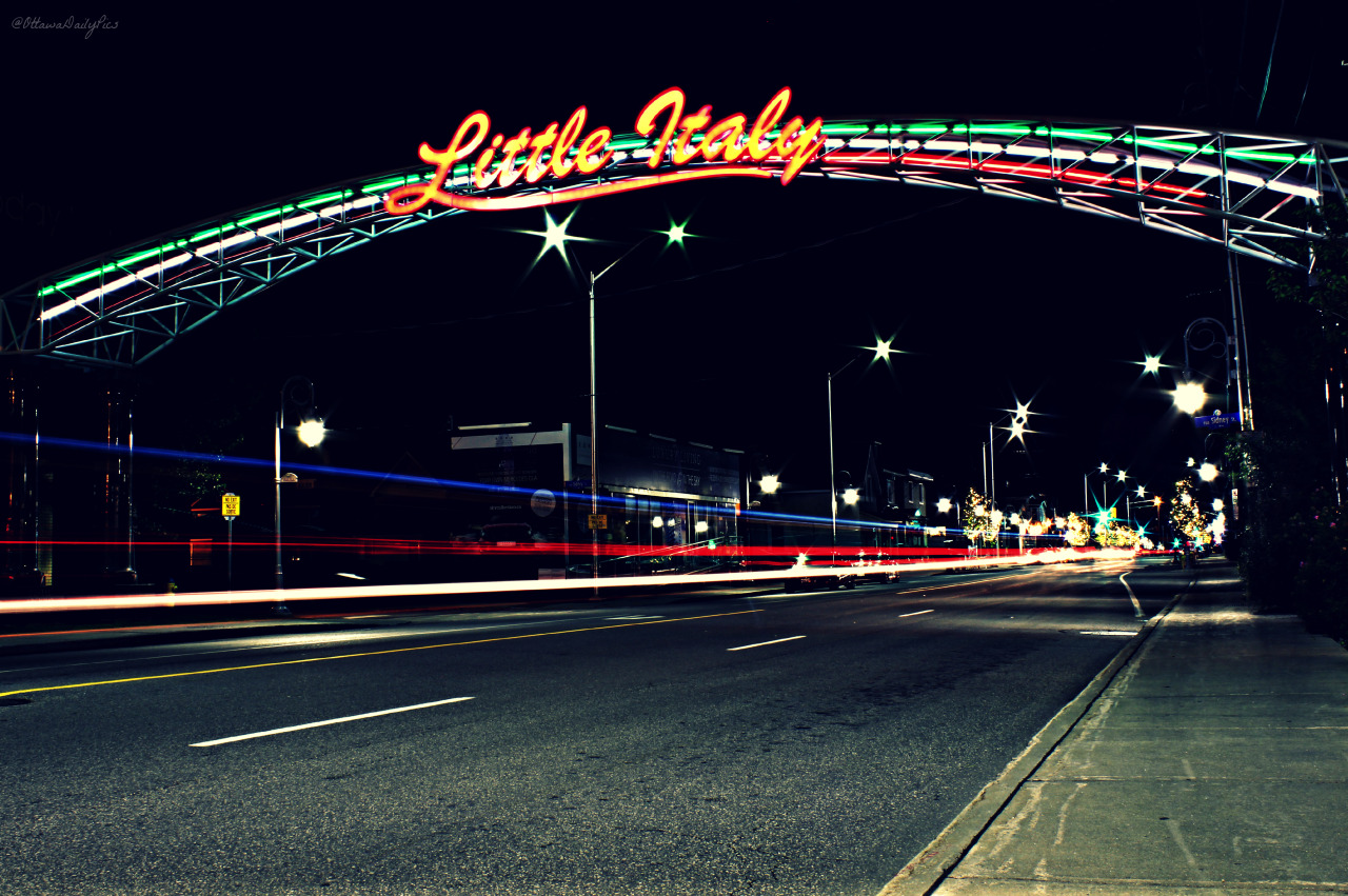 Cars drive by the welcome sign in Little Italy on Preston