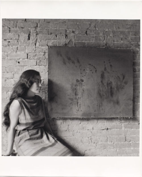 huldrapress:George Maciunas’ photograph of Yoko Ono with her Painting to See in the Dark (Version 1)