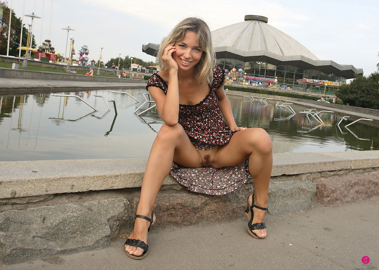 Lovely girl sitting on the edge of a pool wearing no panties 