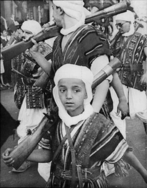 Algerian boy with ceremonial blunderbuss marches with a local chieftan’s honor guard, 1968.