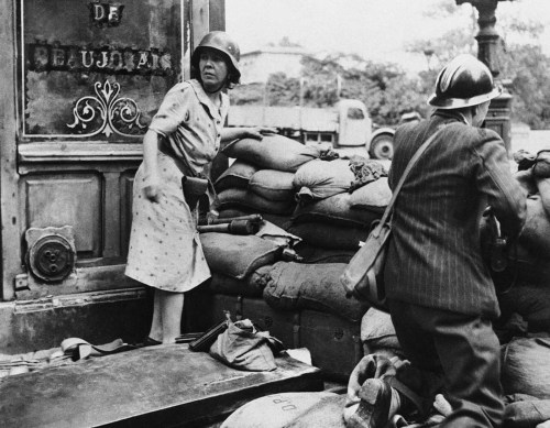 A French man and woman fight with captured German weapons in Paris(August 1944).  Both civilians and