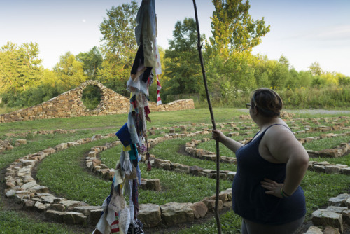 Margaret holding the Diversity Dream Scroll wiht the rising moon above the Moon Gate. Mandala Gardens. Photo credit Gregory Wendt