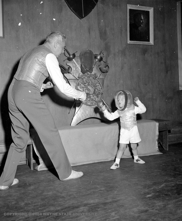 modernfencing:  [ID: a man instructing a young child in fencing, with short foils.