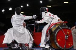 modernfencing:[ID: two wheelchair epee fencers in a bout. The fencer on the right is hitting her opponent, and her blade is bending in an ‘S’.]Fencing at the 2012 Paralympics!