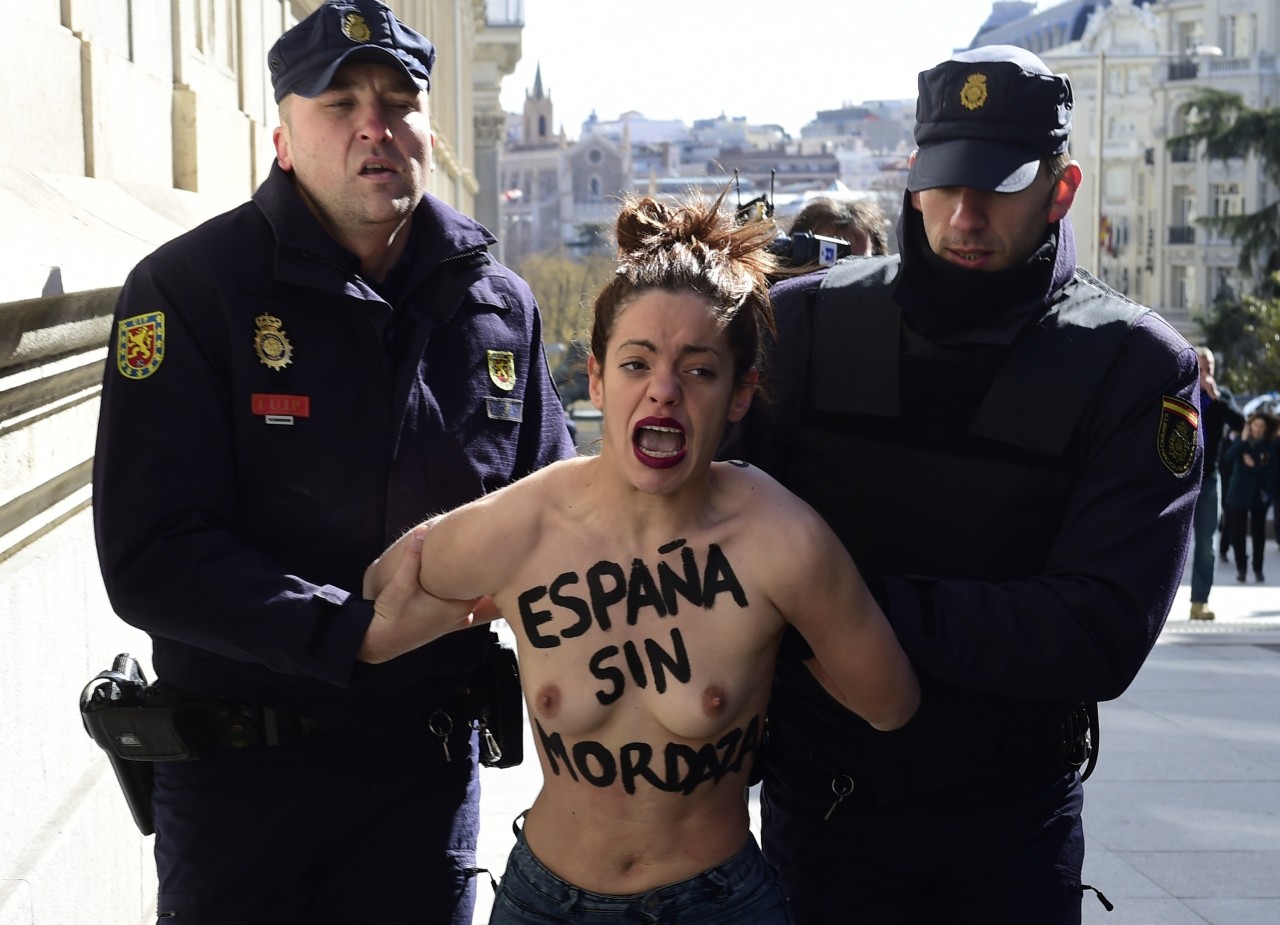ESPAÑA. Dos activistas de Femen protestan frente al Congreso contra la ‘ley mordaza’al grito de “Protestar no es ilegal” y con los lemas “Femen for freedom” y “España sin mordaza” escritos en el torso y en la espalda desnudos. (AFP)