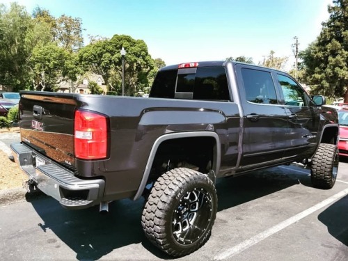 GMC Sierra wearing Ironman All Country M/T tires on KMC XD828 Gloss Black Milled