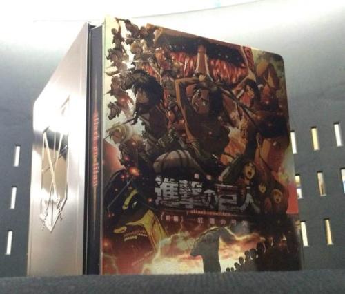 New look at the 1st SnK compilation film, Shingeki no Kyojin Zenpen: ~Guren no Yumiya~’s DVD/Blu-Ray packaging (Drawn by Isayama), the bonus merchandise, and the limited edition “Steel Book” bonus! (Source)The new illustration features