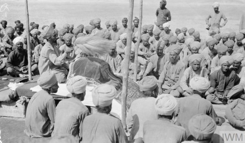 Sikh infantrymen attend a Diwan while on campaign in the Mesopotamian deserts (1918).