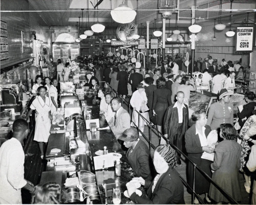 A large lunch spot in Harlem with counter dining and a deli counter, 1942.Photo: NYPL