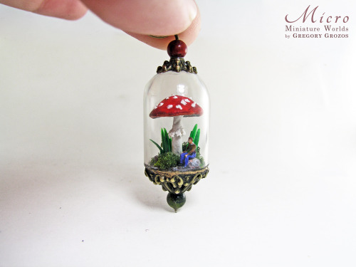 Miniature world pendant. Tiny man resting under a fly agaric mushroom and giant blades of grass and 