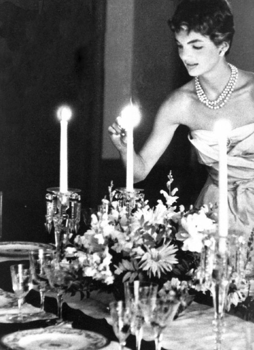 thekennedyclan: 1953, Jackie Kennedy lights candles for a dinner with friends, months after her wedd