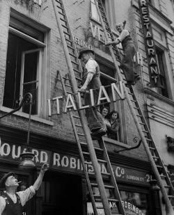 historicaltimes:  Shopkeeper removing the