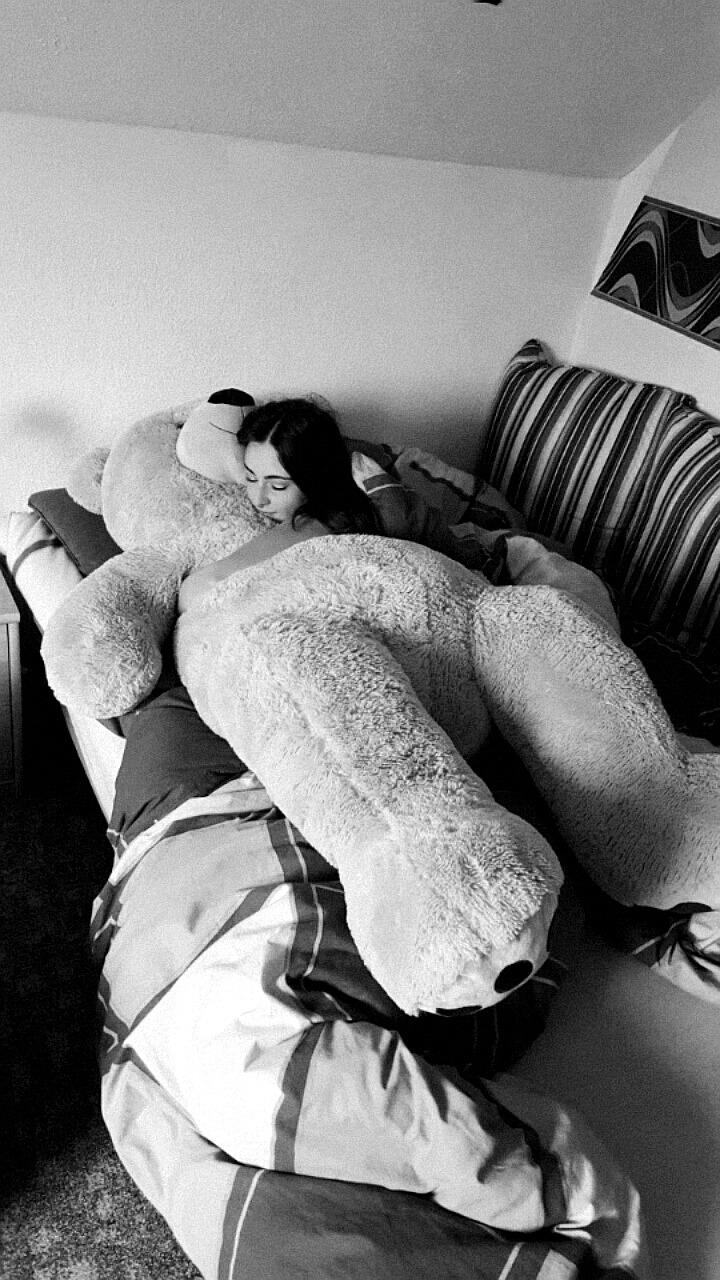 girl cuddling with giant teddy bear