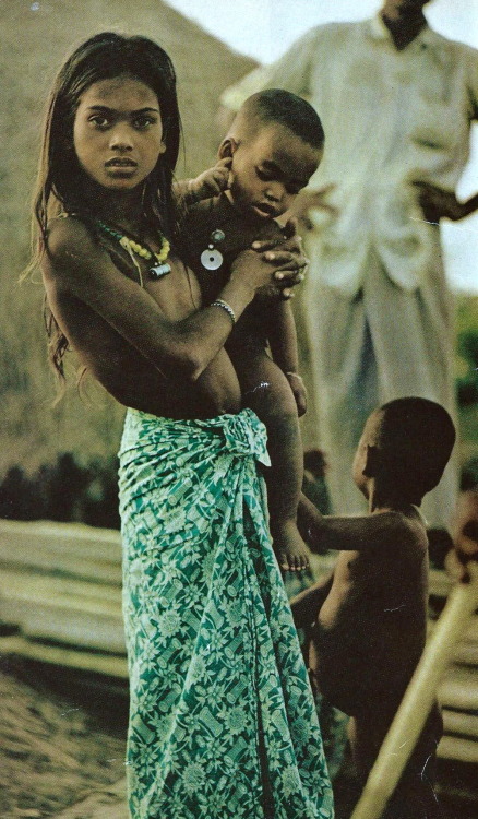 vintagenatgeographic: A village girl near Chiringa, Bangladesh carries a smaller child while her mot
