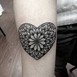 pequenostatuajes:  Tatuaje de un corazón que deja ver un mandala tras de sí, situado en el antebrazo. Artista tatuador: Kirk Nilsen