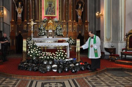 Polish priest blessing motorcycle helmets before a motorcycle pilgrimage. Rekownica, 2014.