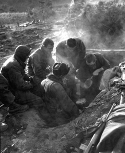 demons:  A heavy mortar company of the 7th Infantry Regiment cooking rice in their foxhole, 7 December 1950 