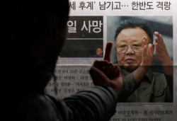  A South Korean man gestures toward a picture