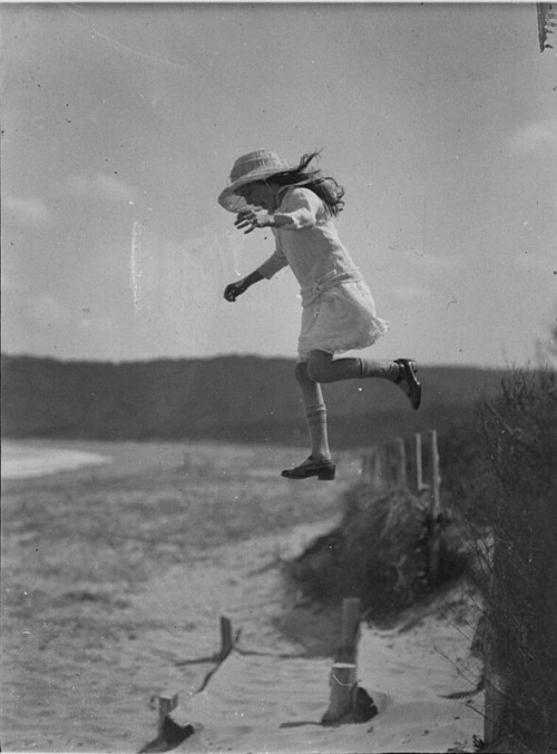 Unidentified small girl leaping onto the beach, c. 1930s