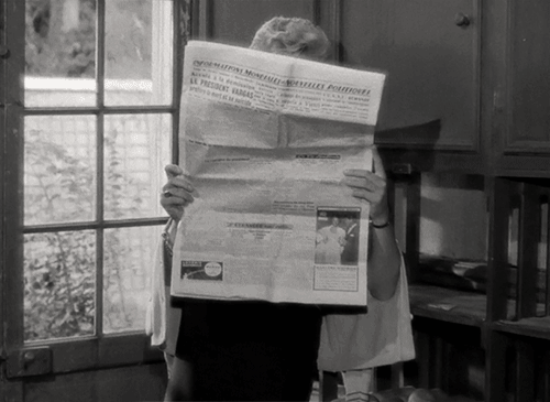 Woman reading newspaper, smoking a cigarette
