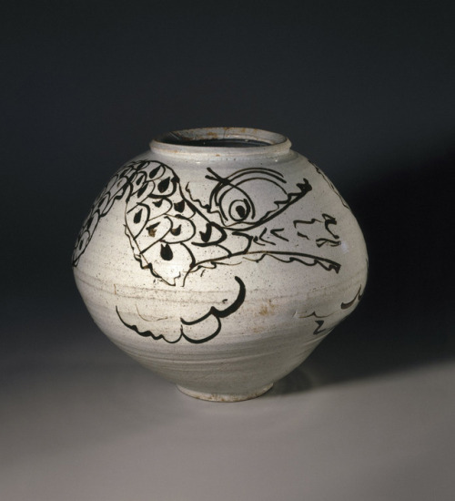 A boldly drawn dragon swirls around the body of this bulbous storage jar. The iron glaze has been ap