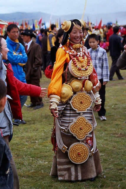 Khampa Tibetan girl from Litang at the Litang Horse festival, dressed head to toe in extremely ornate traditional jewelry and amulets which are specific to the Litang region. These costumes are so heavy and require hours to put on, so they are only...