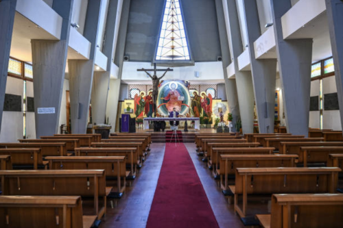 Don Piero Belluso is live-streaming the Mass through his mobile phone, in a deserted church, March 2