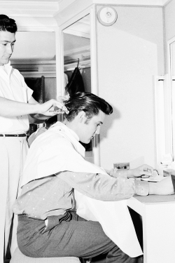 vinceveretts:  Original caption:  During the filming of Hal Wallis’ “Loving You”, May 15, 1957, a young Elvis Presley had his hair trimmed every ten days by studio barber Ramiro Jaloma.  The clipping took place in Presley’s set dressing room.