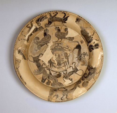 lionofchaeronea:Black-figure terracotta plate with a Gorgon’s head surrounded by bands of mythical a