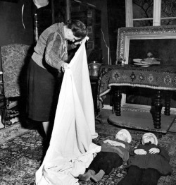 German woman using sheet to cover bodies