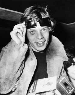 sixtiesgaragefuzzbeatpsychyeye:   Mick with a black eye  Mick Jagger lifting up his sunglasses to  reveal a black eye, which he received on tour in France in  Marseille, as he signs  autographs for fans at London Airport, April 6th 1966.  