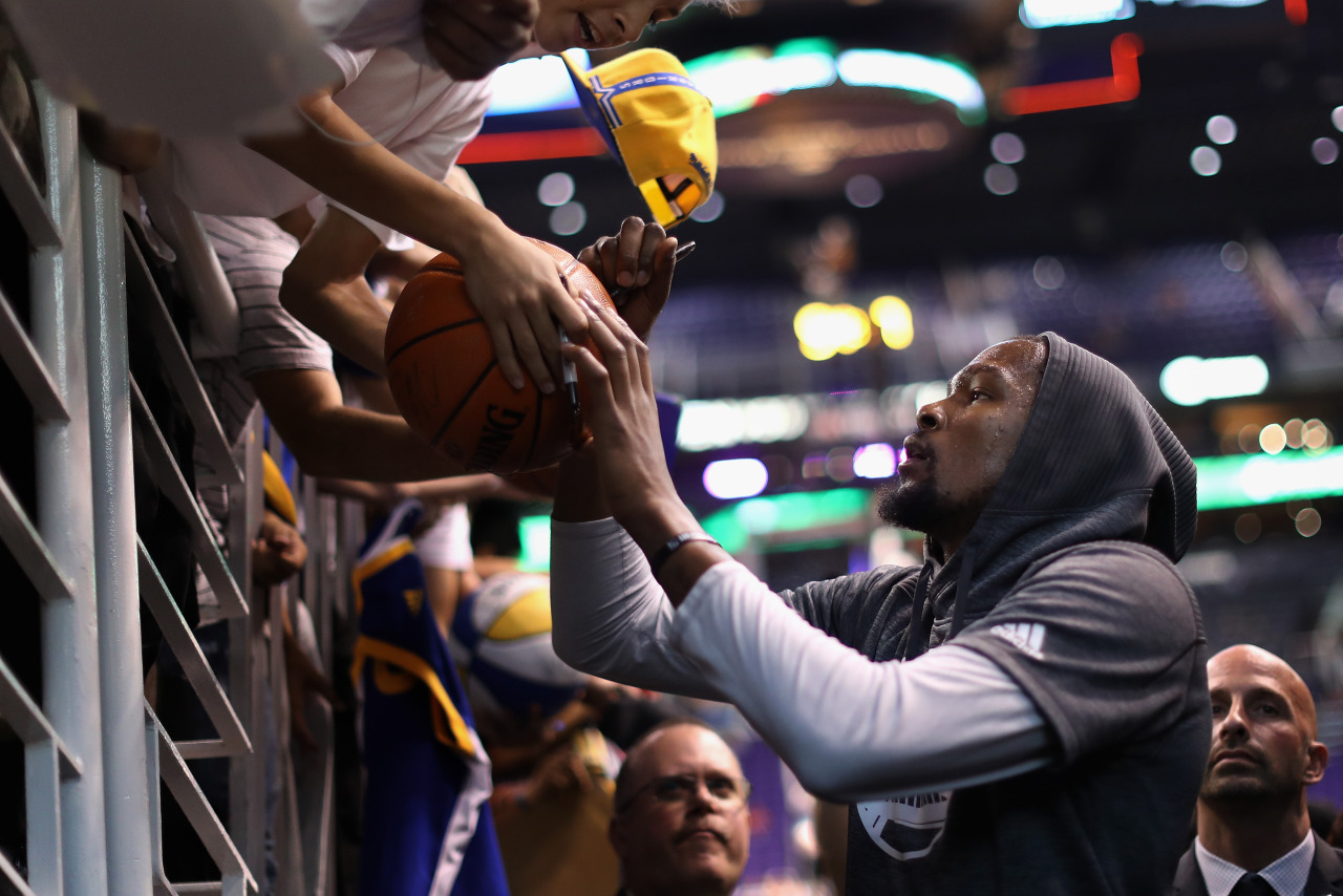 PHOENIX, AZ - OCTOBER 30: Kevin Durant #35 of the Golden State Warriors signs autographs for fans before the NBA game against the Phoenix Suns at Talking Stick Resort Arena on October 30, 2016 in Phoenix, Arizona. NOTE TO USER: User expressly...