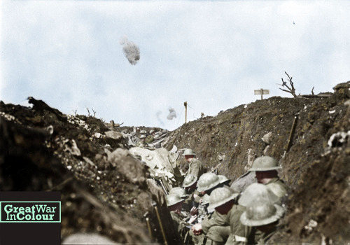 Canadian soldiers in a reserve trench, during the battle of the Somme, watch shrapnel bursts above t