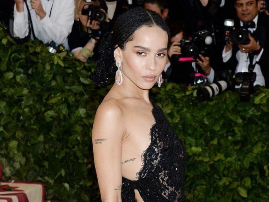 Zoe Kravitz Paparazzi Braless Photos Hot actress with tattoos on her body, Zoe Kravitz, is in an elegant dress that is doing little to cover her  firm body at the Canes film festival. She is here to see some new movies and she hopes that she is going