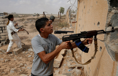 gunrunnerhell:Chin ShotA fighter fires his gun at Islamic State positions during a battle in Sirte. 